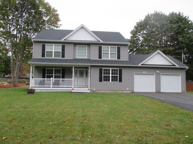 view of front of property with a porch, a garage, and a front lawn