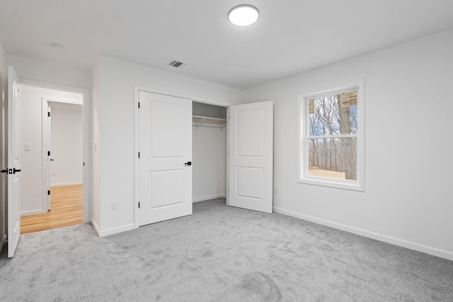 unfurnished bedroom featuring a closet and light carpet