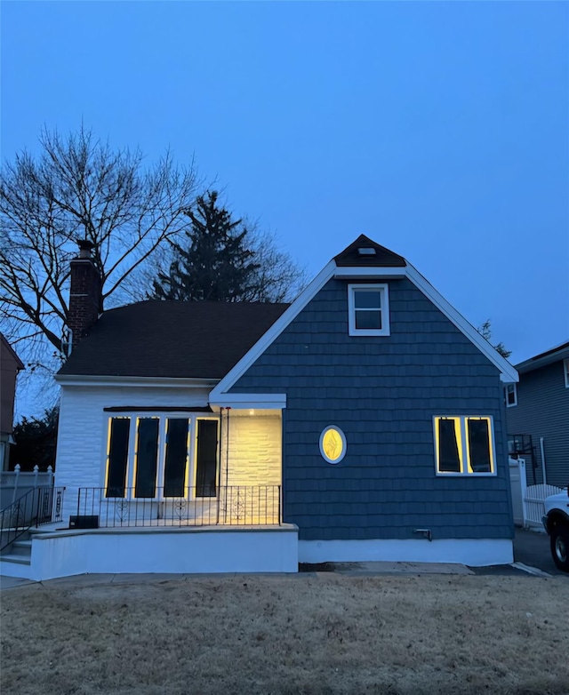 rear view of house with fence and a chimney