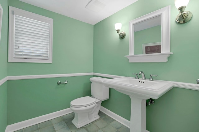 half bathroom with toilet and baseboards