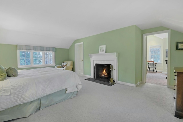 bedroom featuring carpet floors, a fireplace, vaulted ceiling, and baseboards