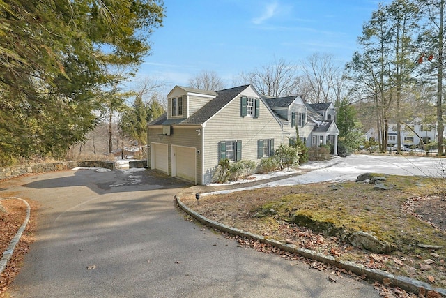 view of side of property with a garage and driveway