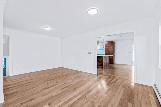 spare room with ornamental molding, light wood-type flooring, and baseboard heating