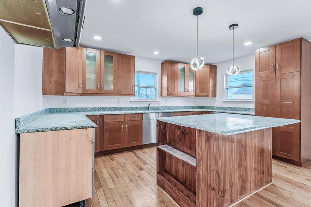 kitchen featuring light stone counters, a center island, light hardwood / wood-style flooring, dishwasher, and pendant lighting