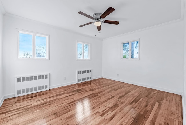 empty room with ceiling fan, ornamental molding, radiator heating unit, and light hardwood / wood-style floors