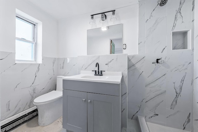 bathroom featuring a tile shower, vanity, tile walls, and toilet