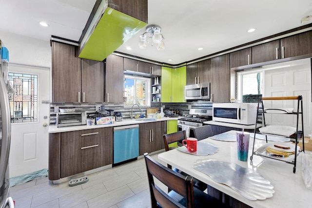 kitchen with tasteful backsplash, dark brown cabinetry, stainless steel appliances, and sink