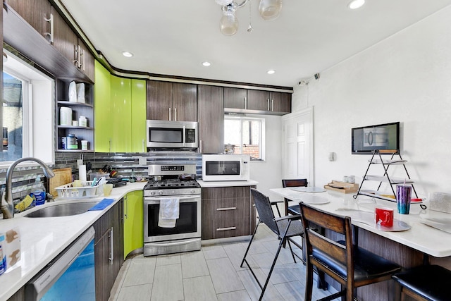 kitchen featuring tasteful backsplash, dark brown cabinetry, appliances with stainless steel finishes, and sink