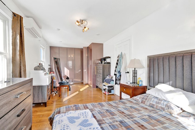 bedroom featuring a wall mounted air conditioner and light wood-type flooring