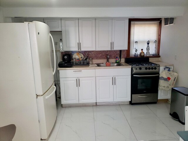 102-17 62nd Dr, Forest Hills, NY 11375 - kitchen featuring freestanding refrigerator, stainless steel range with gas cooktop, a sink, decorative backsplash, and light marble finish floors