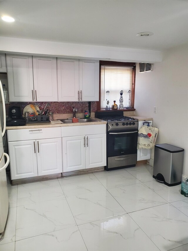 102-17 62nd Dr, Forest Hills, NY 11375 - kitchen featuring stainless steel gas range oven, a sink, light marble finish floors, white cabinets, and light countertops