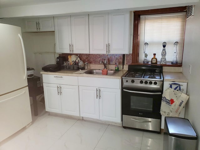 102-17 62nd Dr, Forest Hills, NY 11375 - kitchen featuring stainless steel range with gas stovetop, freestanding refrigerator, a sink, light marble finish floors, and tasteful backsplash