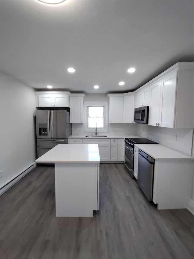 kitchen with a kitchen island, sink, white cabinets, stainless steel appliances, and dark wood-type flooring