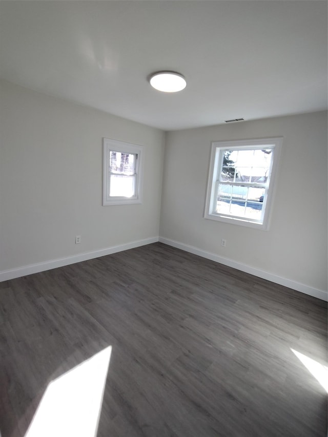 unfurnished room with dark wood-type flooring