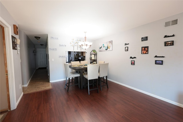 dining area featuring dark hardwood / wood-style floors and a notable chandelier