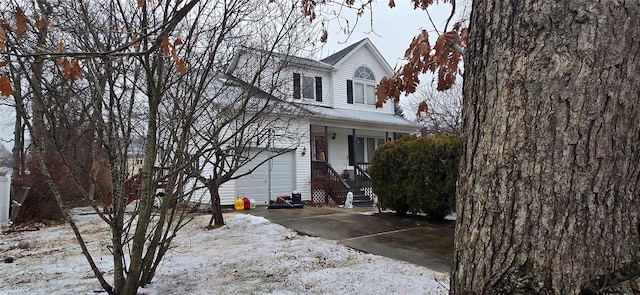 view of property with a garage and a porch