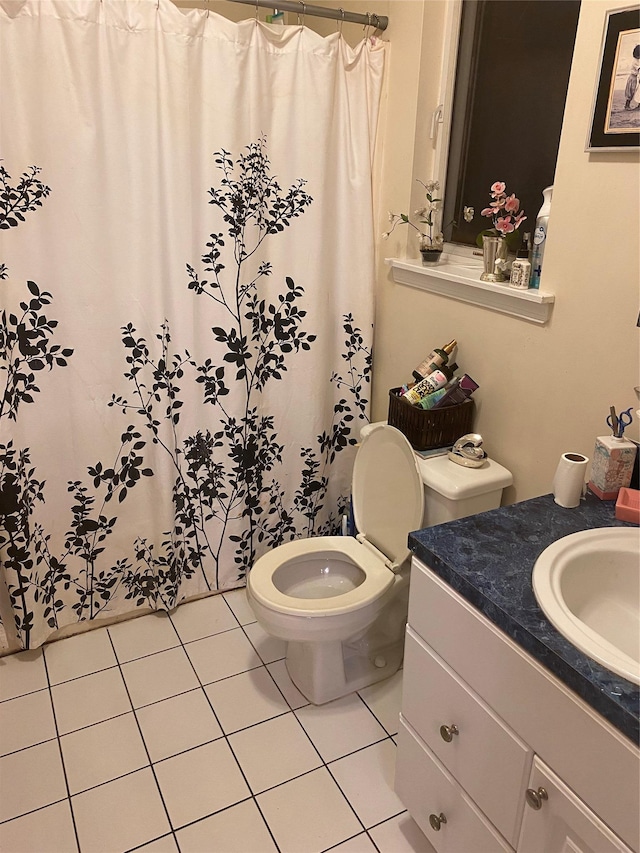 bathroom featuring tile patterned flooring, vanity, and toilet