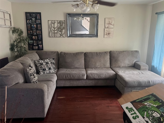 living room featuring dark wood-type flooring and ceiling fan