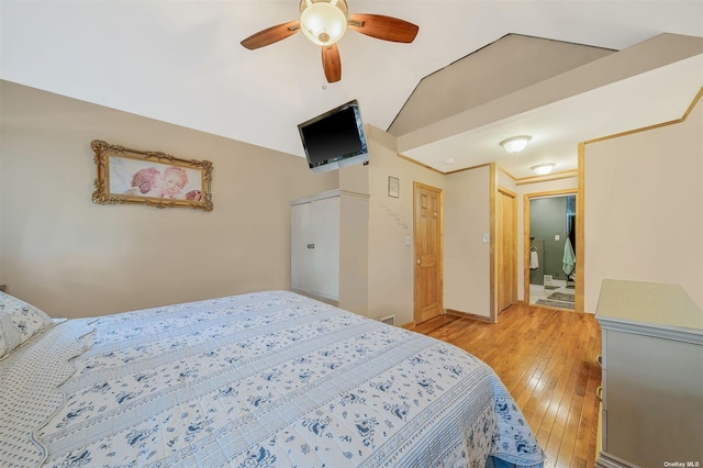 bedroom with vaulted ceiling, connected bathroom, ceiling fan, and light hardwood / wood-style floors