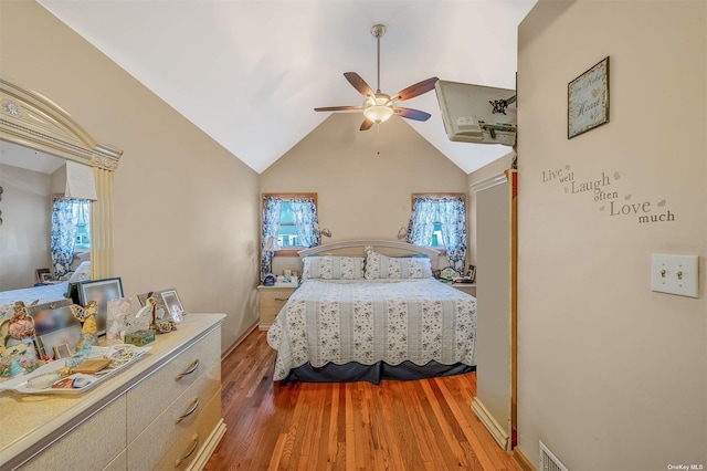 bedroom featuring wood-type flooring, high vaulted ceiling, and ceiling fan