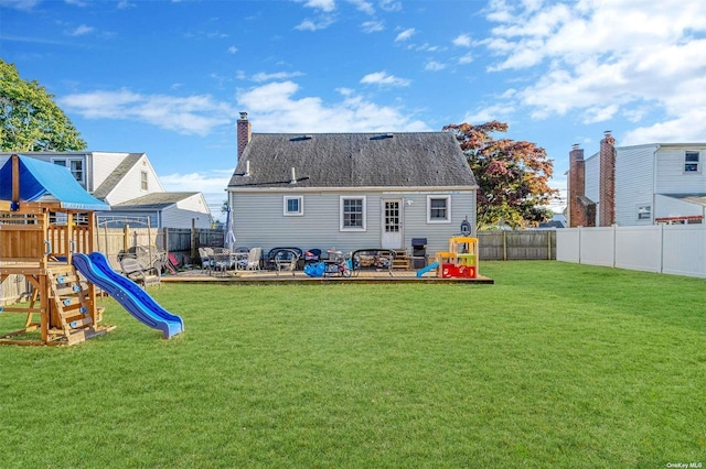 rear view of house with a playground, a patio, and a lawn