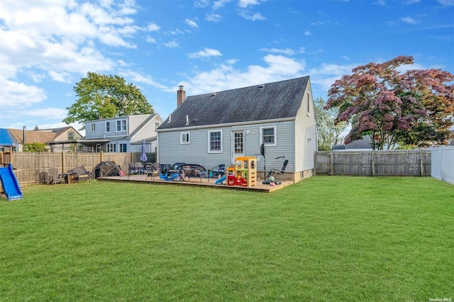 back of house featuring a playground, a yard, and a patio area