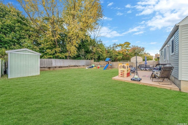 view of yard with a shed, a patio area, and a playground