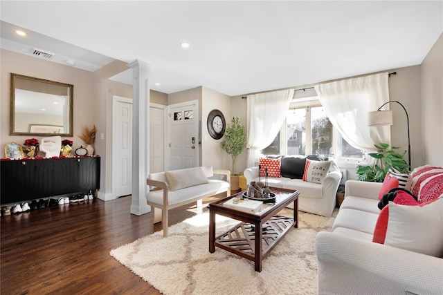 living room featuring dark hardwood / wood-style flooring and ornate columns