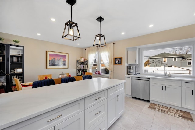 kitchen with white cabinetry, pendant lighting, sink, and stainless steel dishwasher