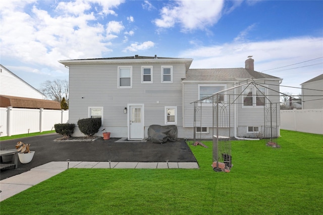 rear view of property with a lawn