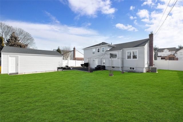 rear view of property featuring a yard and central air condition unit