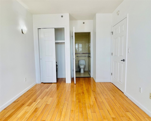 unfurnished bedroom featuring a closet, connected bathroom, and light hardwood / wood-style flooring