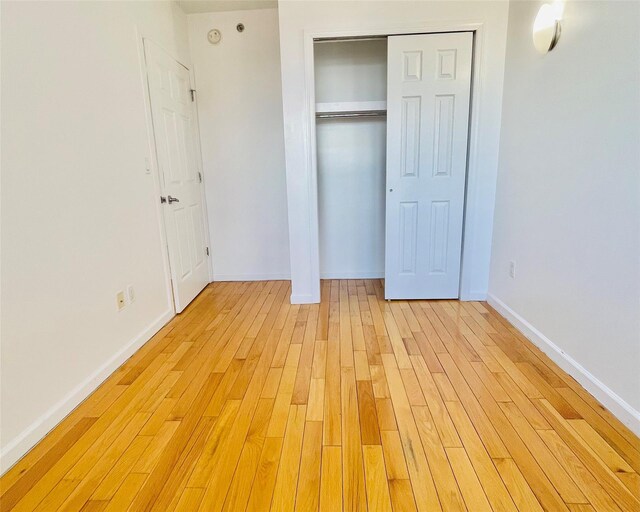 unfurnished bedroom featuring a closet and light hardwood / wood-style flooring