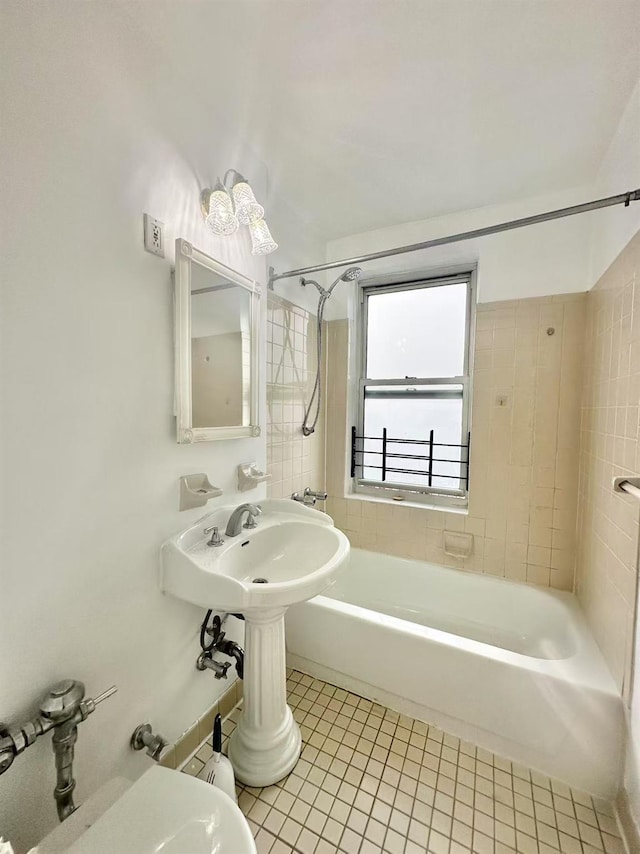 bathroom with tile patterned flooring, tiled shower / bath combo, and toilet