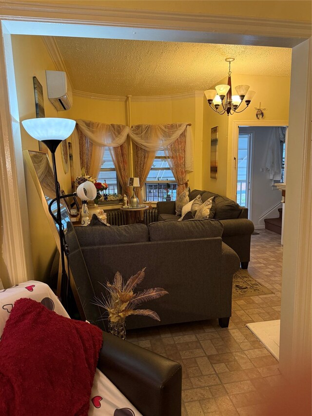 living room featuring a textured ceiling, a wall mounted AC, an inviting chandelier, ornamental molding, and stairs