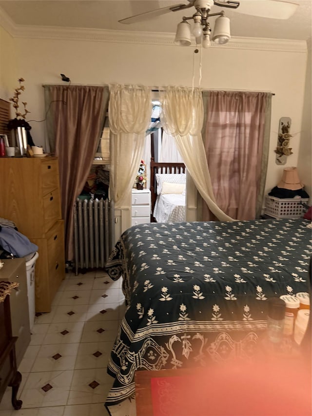 bedroom with radiator heating unit, ceiling fan, ornamental molding, and light tile patterned floors
