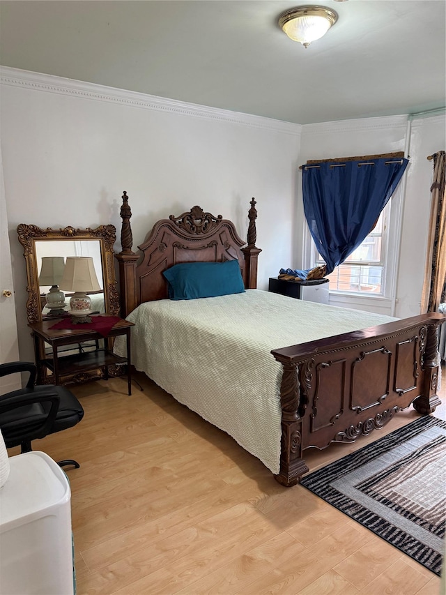 bedroom featuring ornamental molding and wood finished floors