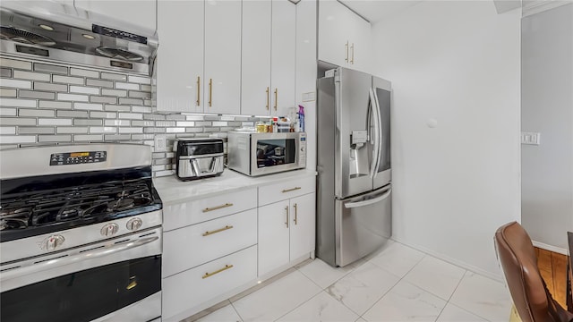 kitchen featuring backsplash, ventilation hood, stainless steel appliances, and white cabinets