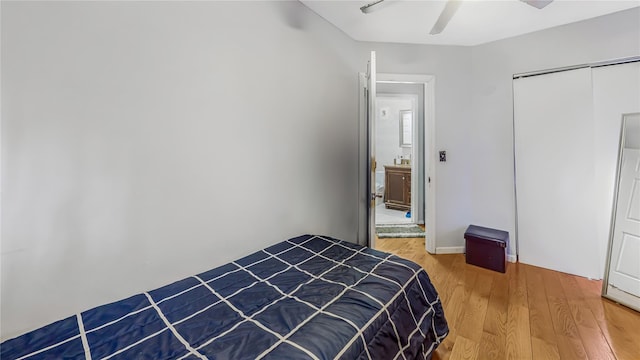 bedroom with hardwood / wood-style flooring, ceiling fan, and a closet