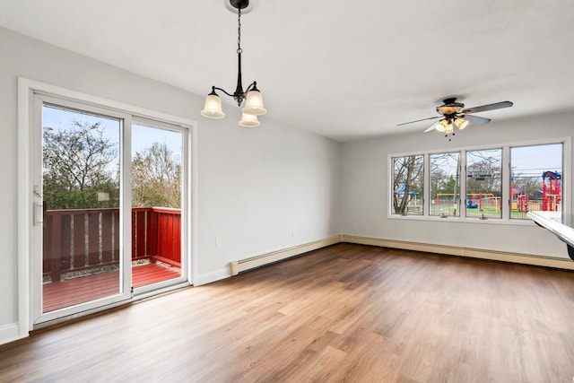 interior space featuring hardwood / wood-style floors, ceiling fan with notable chandelier, a wealth of natural light, and a baseboard heating unit