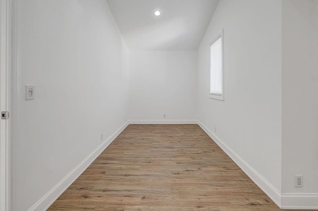 unfurnished room featuring vaulted ceiling and light wood-type flooring