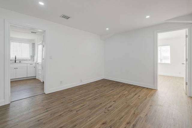 unfurnished room with sink and wood-type flooring