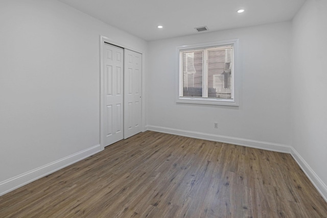 unfurnished bedroom featuring hardwood / wood-style flooring and a closet