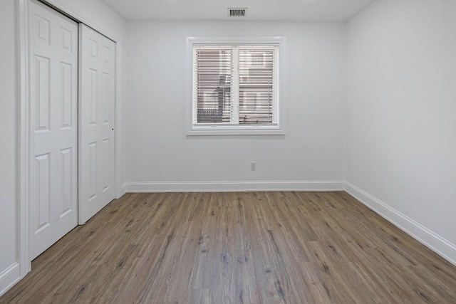 unfurnished bedroom with hardwood / wood-style flooring and a closet