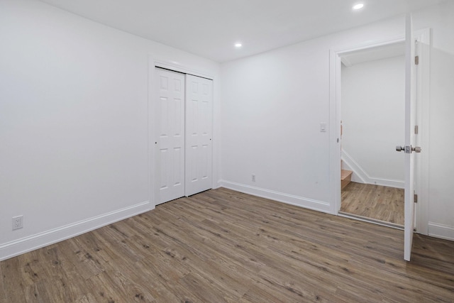 unfurnished bedroom with hardwood / wood-style floors and a closet