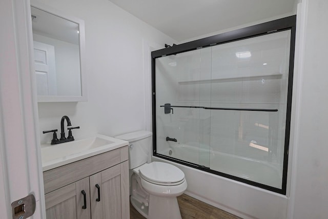 full bathroom featuring vanity, wood-type flooring, enclosed tub / shower combo, and toilet