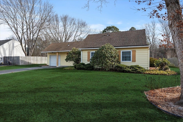 ranch-style home featuring a garage and a front lawn