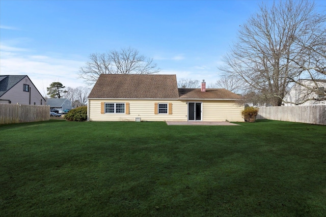 back of property with a lawn and a patio