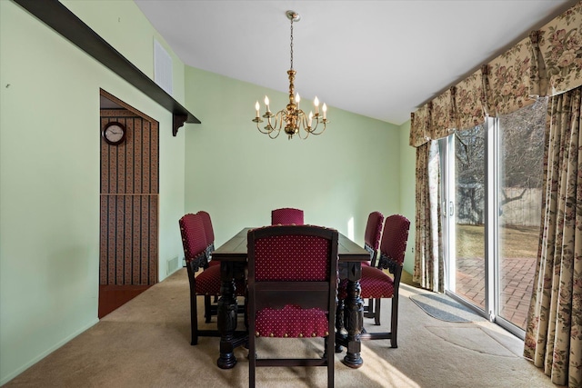 carpeted dining area featuring vaulted ceiling and a chandelier