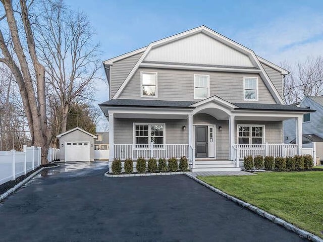 view of front of home featuring a porch, a garage, an outdoor structure, and a front lawn